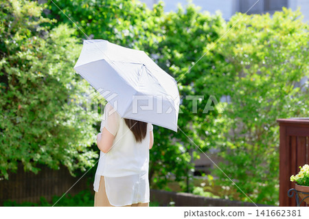 一位二十多歲的女子撐著陽傘。 141662381