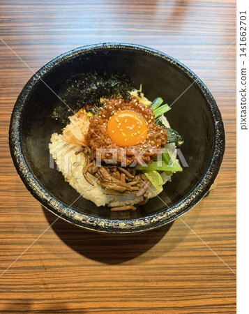 A piping hot stone-grilled bibimbap served in a bowl. A piping hot stone-grilled bibimbap served in a bowl. 141662701
