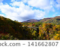 一座橫跨山巒的橋樑，山上覆蓋著秋葉。 141662807