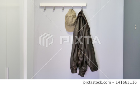 Jacket and Cap Hanging on a Hook Rack in an Entryway Jacket and Cap Hanging on a Hook Rack in an Entryway 141663116