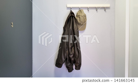Jacket and Cap Hanging on a Hook Rack in an Entryway Jacket and Cap Hanging on a Hook Rack in an Entryway 141663145