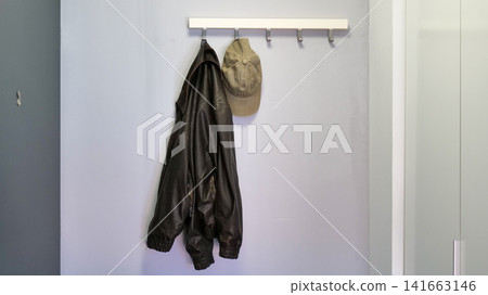 Jacket and Cap Hanging on a Hook Rack in an Entryway Jacket and Cap Hanging on a Hook Rack in an Entryway 141663146