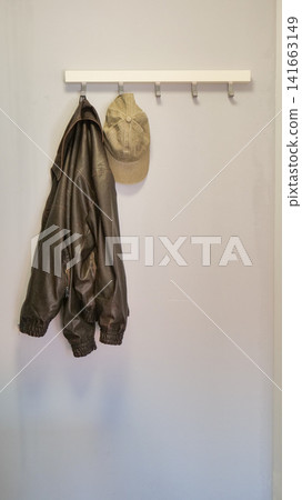 Jacket and Cap Hanging on a Hook Rack in an Entryway Jacket and Cap Hanging on a Hook Rack in an Entryway 141663149