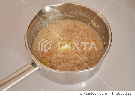 Butter Melting in Oatmeal in a Cooking Pot Butter Melting in Oatmeal in a Cooking Pot 141663182