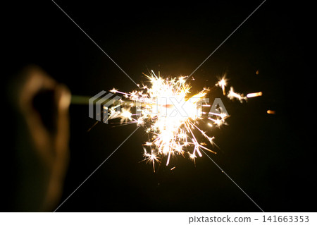 People enjoying handheld fireworks. People enjoying handheld fireworks. 141663353