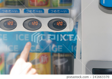 A woman buying a drink from a vending machine on a hot day. A woman buying a drink from a vending machine on a hot day. 141663370