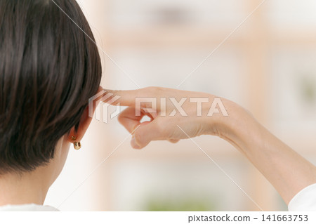 A woman pointing to her head A woman pointing to her head 141663753