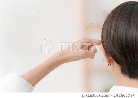 A woman pointing to her head A woman pointing to her head 141663754