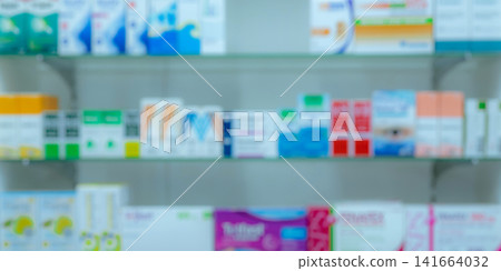 Blurred pharmacy shelf filled with medicine boxes and pharmaceutical products. Healthcare background for hospital, pharmacy, prescription drug and medical industry concept. Hospital services. Blurred pharmacy shelf filled with medicine boxes and pharmaceutical products. Healthcare background for hospital, pharmacy, prescription drug and medical industry concept. Hospital services. 141664032