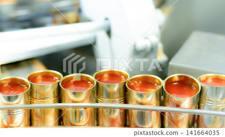 Canned fish factory. Food industry. Sardines in red tomato sauce in tinned cans at food factory. Food processing production line. Food manufacturing industry. Many can of sardines on a conveyor belt. Canned fish factory. Food industry. Sardines in red tomato sauce in tinned cans at food factory. Food processing production line. Food manufacturing industry. Many can of sardines on a conveyor belt. 141664035