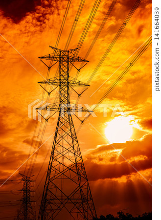 High voltage electricity transmission tower silhouetted against golden sunset sky with power lines stretching across the horizon, illustrating energy infrastructure, electric grid and utility concepts High voltage electricity transmission tower silhouetted against golden sunset sky with power lines stretching across the horizon, illustrating energy infrastructure, electric grid and utility concepts 141664039