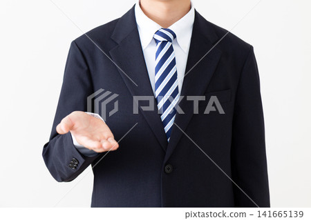 一位身穿西裝的年輕商人擺出了一個標準的姿勢。 一位身穿西裝的年輕商人擺出了一個標準的姿勢。 141665139