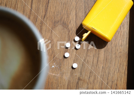 small yellow plastic container dispensing white artificial sweetener tablets small yellow plastic container dispensing white artificial sweetener tablets 141665142