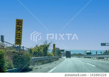 Warning sign for rear-end collisions on a road overlooking the sea. Warning sign for rear-end collisions on a road overlooking the sea. 141665228