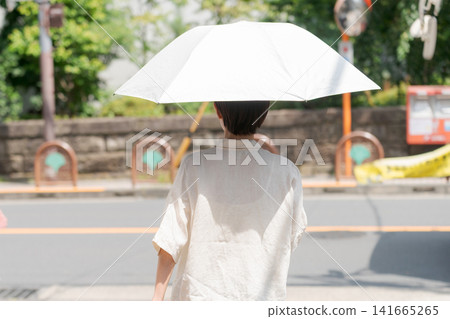 拿著遮陽傘的婦女的後面 拿著遮陽傘的婦女的後面 141665265