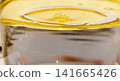 Golden yellow oil layer floating over water surface macro view pure natural vegetable olive oil liquid texture background photo image photography stock asset element 141665426