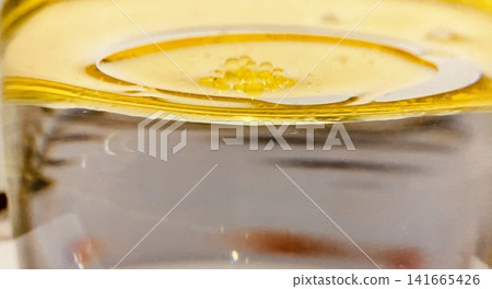 Golden yellow oil layer floating over water surface macro view pure natural vegetable olive oil liquid texture background photo image photography stock asset element Golden yellow oil layer floating over water surface macro view pure natural vegetable olive oil liquid texture background photo image photography stock asset element 141665426