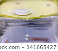 Macro shot of yellow oil droplets floating on water surface liquid separation science experiment cooking oil chemistry concept abstract close up macro photo image background 141665427