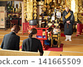 A monk and bereaved family bowing during a memorial service. A monk and bereaved family bowing during a memorial service. 141665509