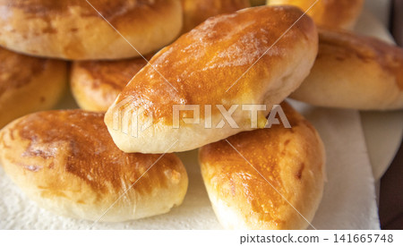 Lots of delicious freshly baked hot pies with stuffing, food background, close-up, Russian cuisine 141665748