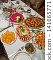 Colorful festive table setting with various traditional dishes and desserts for celebration 141665771