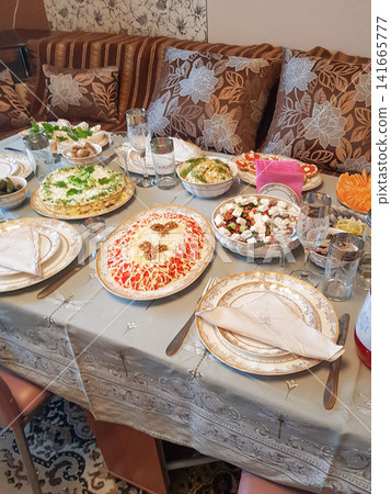 Traditional Middle Eastern dining table set with various dishes and decorative tableware Traditional Middle Eastern dining table set with various dishes and decorative tableware 141665777
