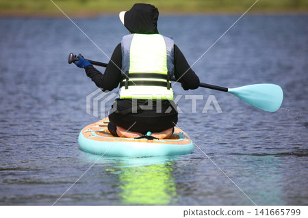 Woman enjoying SUP Woman enjoying SUP 141665799