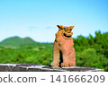 The majestic Shisa statues at Ishigaki Island's Sokohara Dam stand proudly against a backdrop of blue sky and green mountains. 141666209
