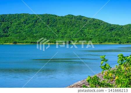 The beautiful scenery of the Sokohara Dam on Ishigaki Island, with its calm blue lake surface and deep green mountains. The beautiful scenery of the Sokohara Dam on Ishigaki Island, with its calm blue lake surface and deep green mountains. 141666213