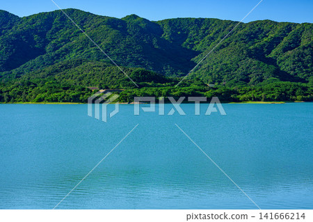 The beautiful scenery of the Sokohara Dam on Ishigaki Island, with its calm blue lake surface and deep green mountains. The beautiful scenery of the Sokohara Dam on Ishigaki Island, with its calm blue lake surface and deep green mountains. 141666214
