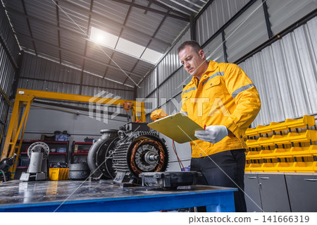 Engineer Checking DC Motor, Technician Man in Garage check inspecting service maintenance Stator. Engineer Checking DC Motor, Technician Man in Garage check inspecting service maintenance Stator. 141666319