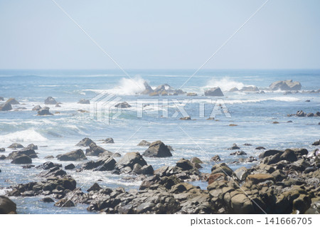 A beautiful coastal landscape where rocky cliffs stretch into the distance and the blue sea meet. 141666705