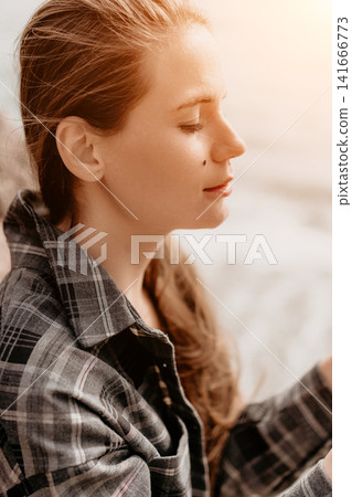 Woman portrait profile serene young lady in a plaid shirt with closed eyes enjoying the warm sunlight outdoors 141666773