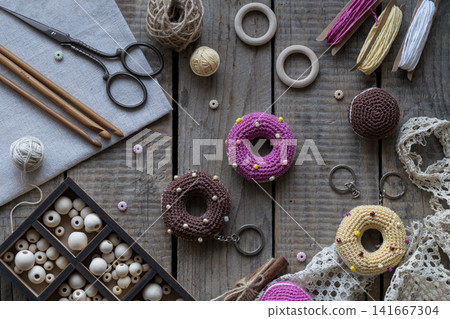 Sewing and knitting tools flat lay with donut pincushions embroidery hoop scissors yarn beads and lace on rustic wooden table cozy handmade craft background Sewing and knitting tools flat lay with donut pincushions embroidery hoop scissors yarn beads and lace on rustic wooden table cozy handmade craft background 141667304