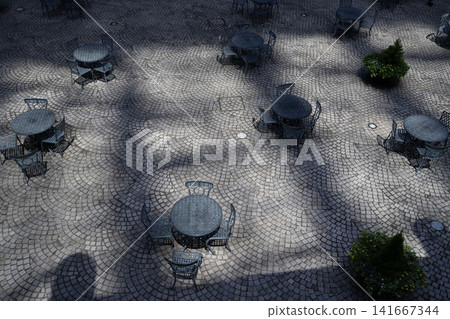 A sophisticated courtyard scene featuring European-style cobblestones and a table set. 141667344