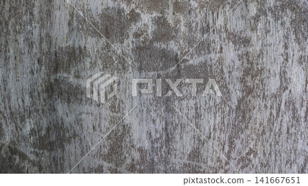 An aged wood surface with a distinct texture. The wood grain has faded over time, creating a gray-beige pattern with vertical cracks and dark, worn spots, as well as a peeling top layer. An aged wood surface with a distinct texture. The wood grain has faded over time, creating a gray-beige pattern with vertical cracks and dark, worn spots, as well as a peeling top layer. 141667651