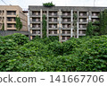 The concrete exterior walls and rusty railings of the Ikeshima Apartments are showing signs of weathering. 141667706