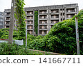 A scene of an unmanned coal mine apartment complex on Ikeshima Island, with vines entwined around the utility poles. 141667711