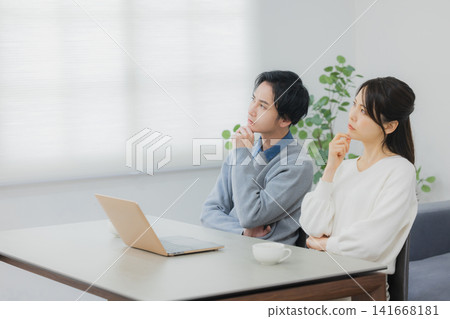 一對年輕夫婦正在努力解決電腦問題。 一對年輕夫婦正在努力解決電腦問題。 141668181