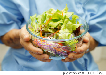 Asian elderly woman patient holding healthy food for patient in hospital, nutrition and vitamin. 141668359
