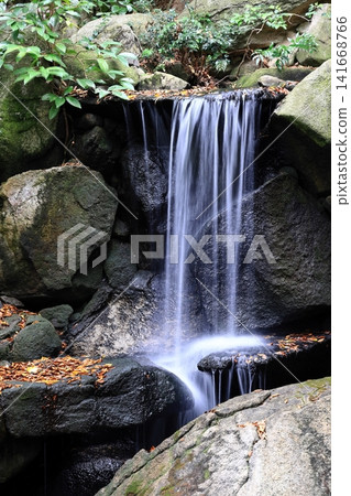 A waterfall in a quietly flowing Japanese garden A waterfall in a quietly flowing Japanese garden 141668766