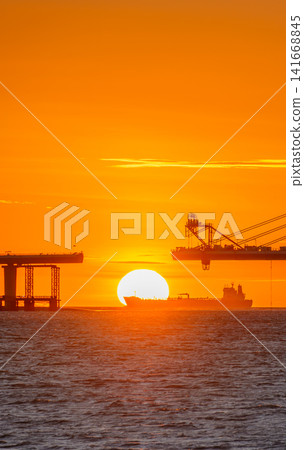 Sunset over Danjiang Bridge and Cargo Ship in Tamsui, Taiwan Sunset over Danjiang Bridge and Cargo Ship in Tamsui, Taiwan 141668845