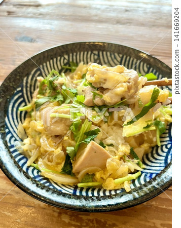 有人用筷子夾起一份自製的親子丼(雞肉雞蛋蓋飯),上面撒滿了三葉芹(日本香菜)。 有人用筷子夾起一份自製的親子丼(雞肉雞蛋蓋飯),上面撒滿了三葉芹(日本香菜)。 141669204
