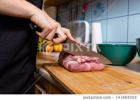 Chef starting to slice big piece of raw meat stock photo Chef starting to slice big piece of raw meat stock photo 141669503
