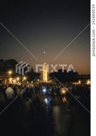 Crowded Marrakech Square at Dusk With Illuminated Minaret Crowded Marrakech Square at Dusk With Illuminated Minaret 141669539