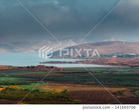 Coastal plain beneath cloudy mountain ridge Coastal plain beneath cloudy mountain ridge 141669706