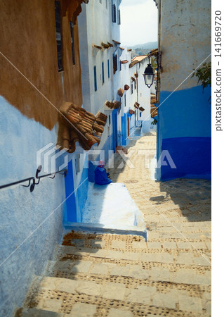 Chefchaouen Narrow alley with blue painted walls Chefchaouen Narrow alley with blue painted walls 141669720