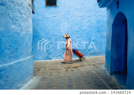 woman walks through the streets of Chefchaouen woman walks through the streets of Chefchaouen 141669724
