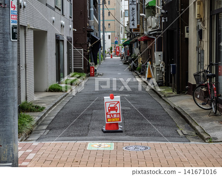 一條狹窄的住宅街道入口處，放置了一個標有「禁止通行」的交通錐。 141671016