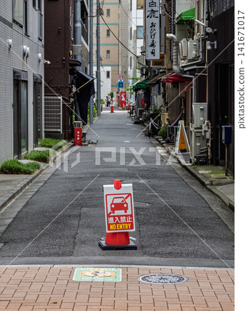 一條狹窄的小巷,擺放著標示「禁止通行」的交通錐——這是城市的一條住宅街道。 一條狹窄的小巷,擺放著標示「禁止通行」的交通錐——這是城市的一條住宅街道。 141671017